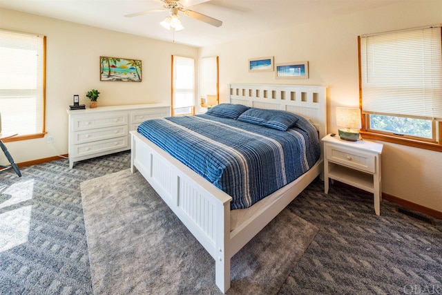 bedroom featuring baseboards, dark colored carpet, and a ceiling fan