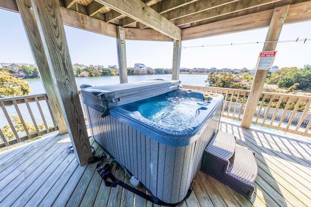 deck featuring a water view and a hot tub