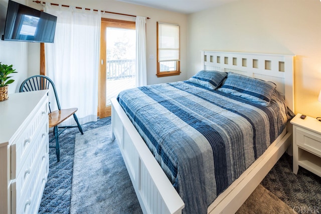 bedroom featuring access to exterior and dark colored carpet