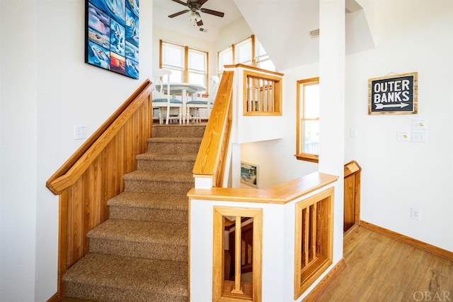 stairs featuring a ceiling fan, visible vents, baseboards, and wood finished floors