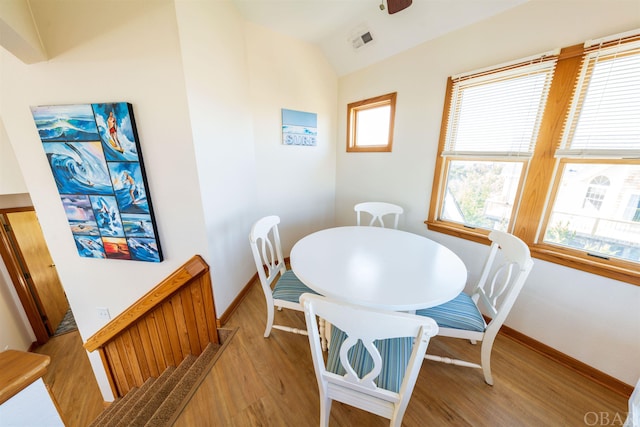 dining room with ceiling fan, lofted ceiling, visible vents, baseboards, and light wood-style floors