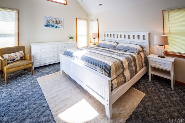 bedroom featuring dark colored carpet, visible vents, and lofted ceiling