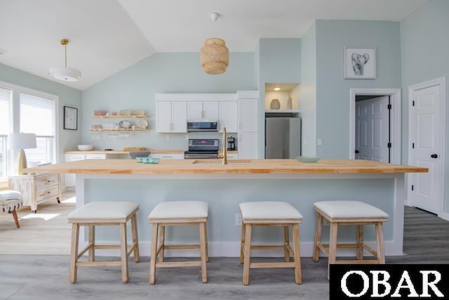 131B Jay Crest Rd Unit 801, Duck, NC 27949 - kitchen featuring appliances with stainless steel finishes, wooden counters, light wood-style floors, a large island, and vaulted ceiling
