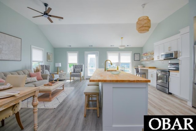 131B Jay Crest Rd Unit 801, Duck, NC 27949 - kitchen with stainless steel appliances, vaulted ceiling, butcher block countertops, open floor plan, and white cabinets