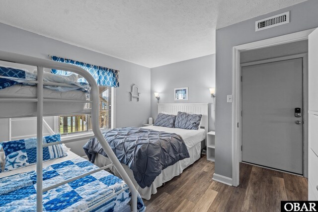 627 Sand Fiddler Cir Unit B-1, Corolla, NC 27927 - bedroom featuring a textured ceiling and wood finished floors