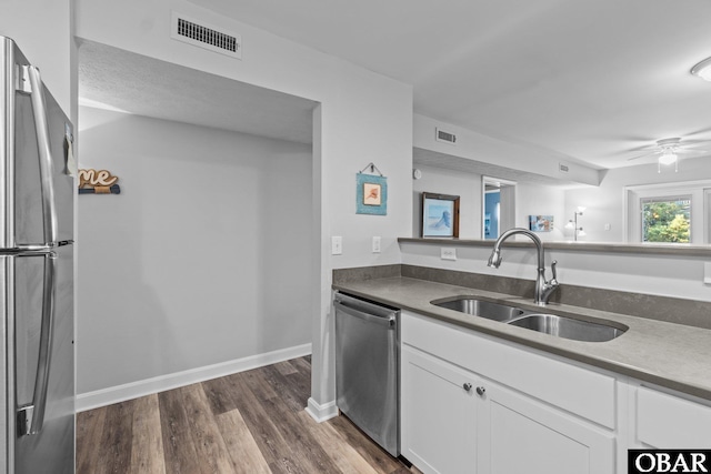 627 Sand Fiddler Cir Unit B-1, Corolla, NC 27927 - kitchen with appliances with stainless steel finishes, white cabinetry, dark wood-type flooring, and a ceiling fan