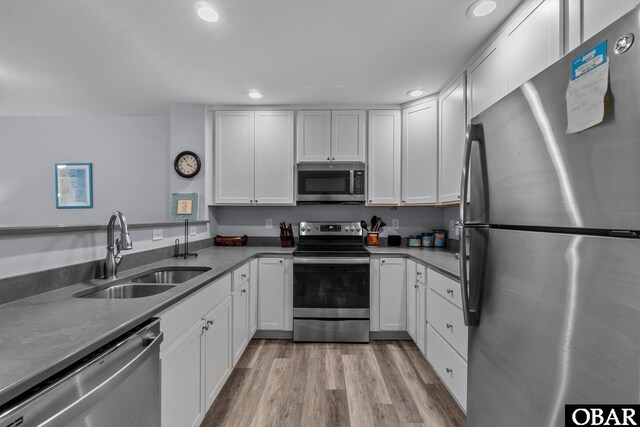 627 Sand Fiddler Cir Unit B-1, Corolla, NC 27927 - kitchen with appliances with stainless steel finishes, white cabinetry, recessed lighting, and light wood-style floors