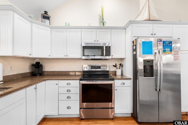 757 Fishermans Ct Lot 66, Corolla, NC 27927 - kitchen featuring white cabinets, stainless steel appliances, light wood-style flooring, and vaulted ceiling
