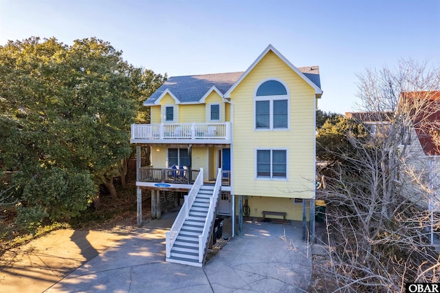 view of front facade featuring stairs, a carport, and driveway