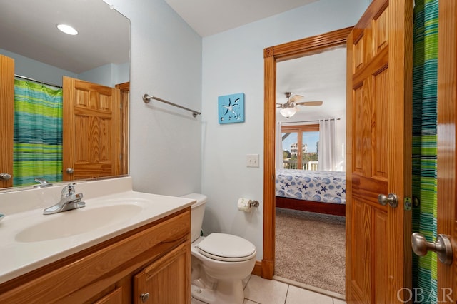 ensuite bathroom with ensuite bathroom, ceiling fan, tile patterned flooring, toilet, and vanity