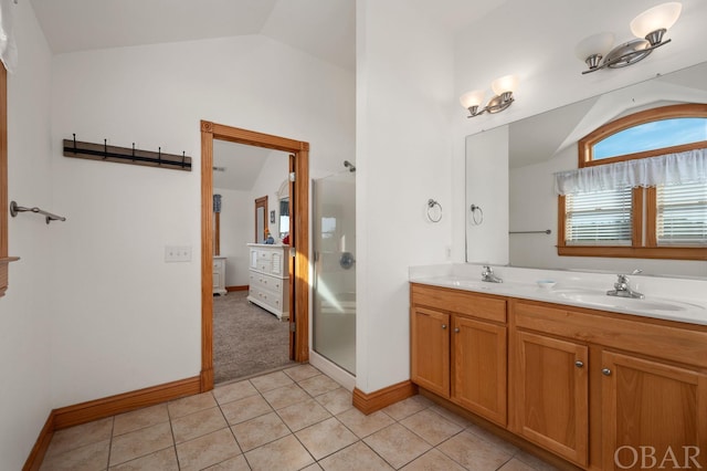 full bath featuring lofted ceiling, double vanity, a sink, and tile patterned floors