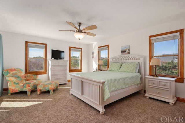 carpeted bedroom with ceiling fan and baseboards