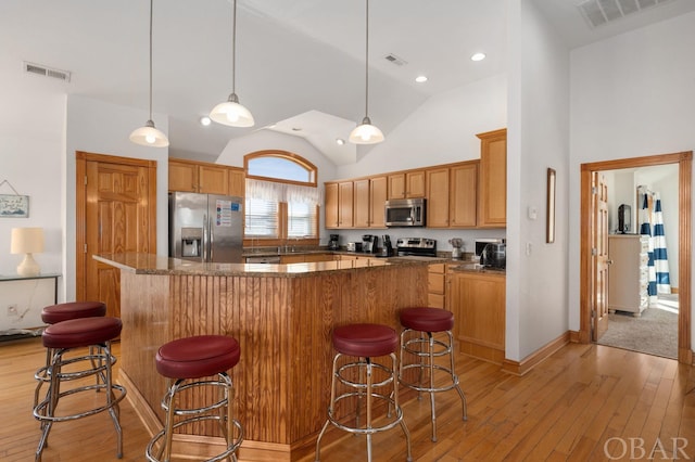 kitchen featuring appliances with stainless steel finishes, a center island, and visible vents