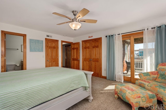 carpeted bedroom featuring access to outside, visible vents, ceiling fan, and ensuite bath