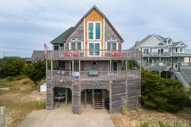 view of front facade with a carport, concrete driveway, and a balcony