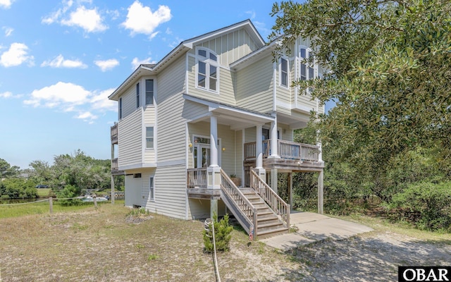 2132 Dolphin Ln Lot 62, Corolla, NC 27927 - view of front of property featuring board and batten siding, covered porch, and stairs