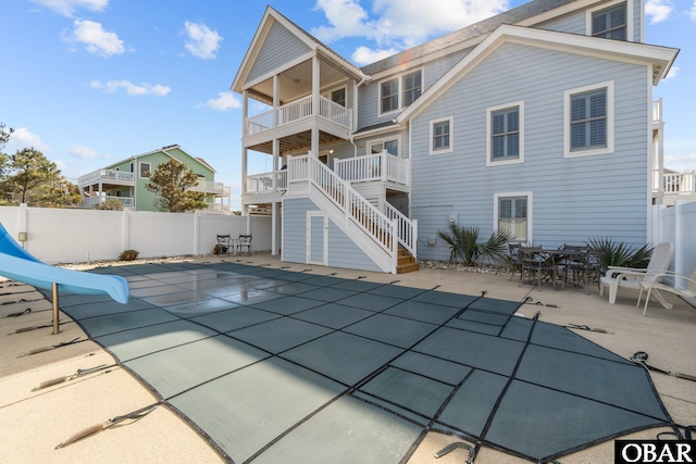 rear view of house with a patio area, stairway, a balcony, and a fenced backyard