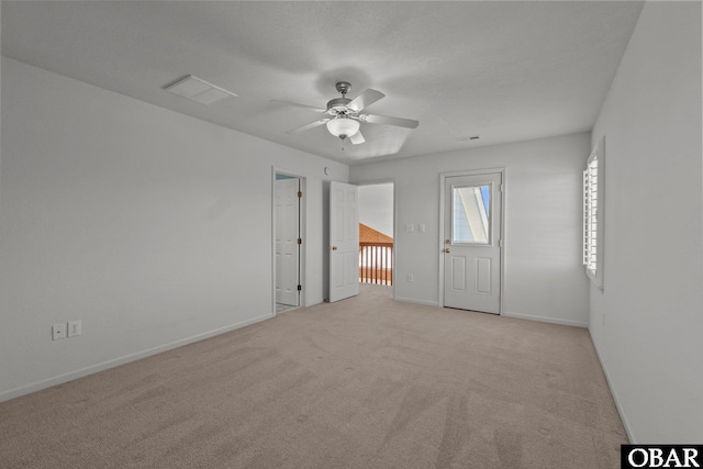 empty room with visible vents, light carpet, baseboards, and ceiling fan