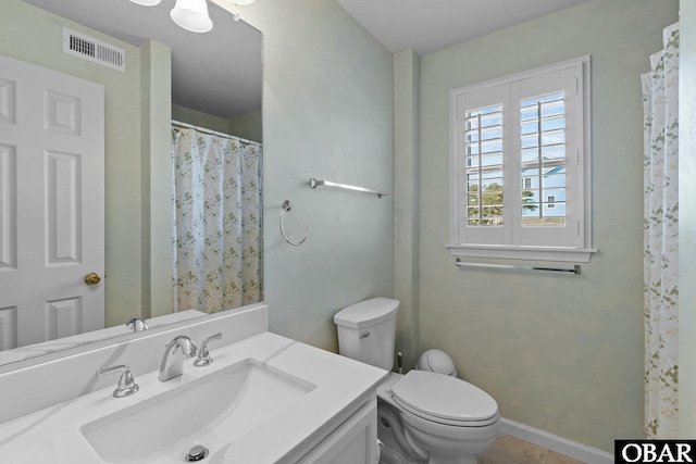 bathroom featuring vanity, a shower with shower curtain, baseboards, visible vents, and toilet