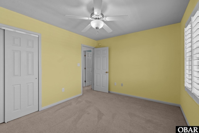 unfurnished bedroom with baseboards, carpet, and ceiling fan