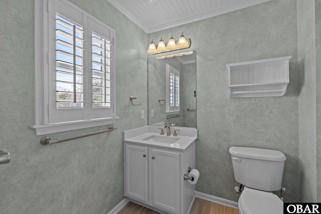 bathroom with vanity, wood finished floors, baseboards, crown molding, and toilet