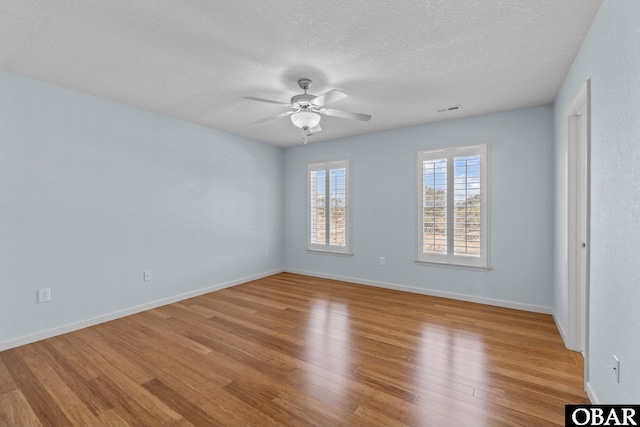 unfurnished bedroom featuring light wood-type flooring, visible vents, a ceiling fan, a textured ceiling, and baseboards