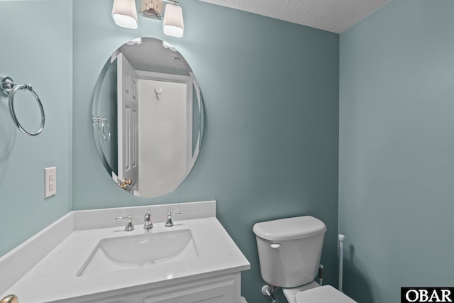 bathroom with toilet, vanity, and a textured ceiling