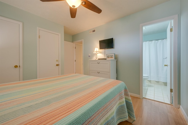 bedroom with visible vents, connected bathroom, baseboards, light wood-type flooring, and a ceiling fan