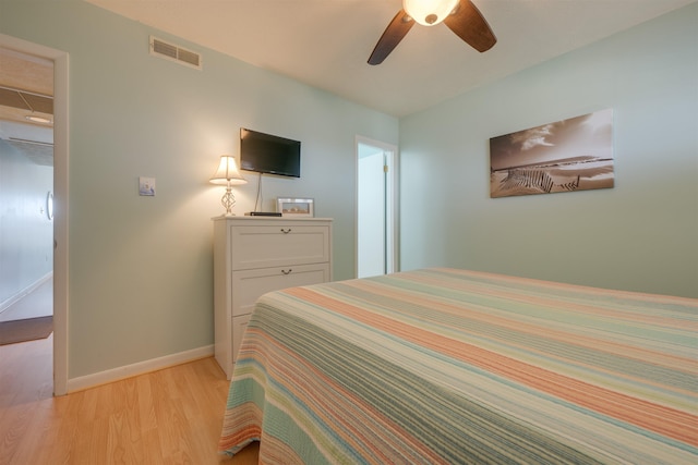 bedroom with light wood-type flooring, visible vents, baseboards, and a ceiling fan