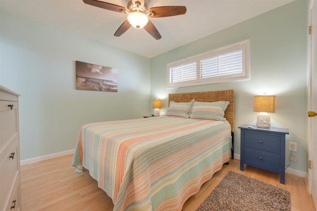 bedroom featuring light wood-style flooring, a ceiling fan, and baseboards