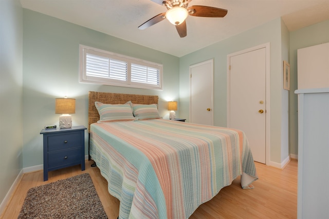 bedroom with light wood-style flooring, baseboards, and ceiling fan