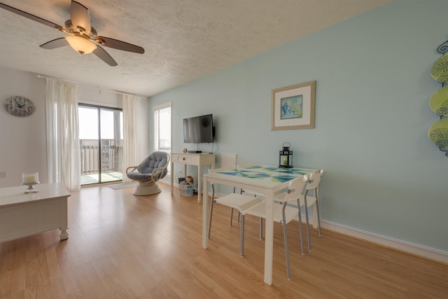 dining area featuring a textured ceiling, light wood-style floors, and ceiling fan