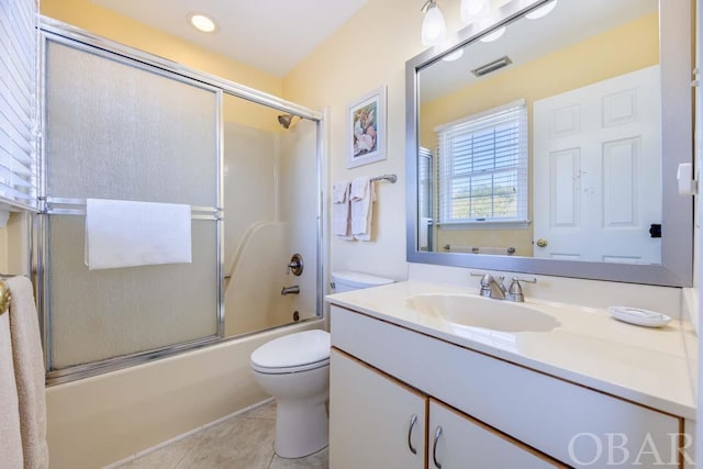 bathroom with visible vents, toilet, enclosed tub / shower combo, tile patterned floors, and vanity