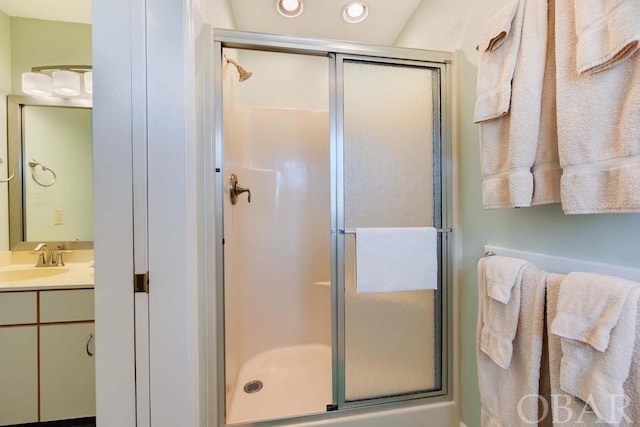 bathroom with recessed lighting, vanity, and a shower with shower door