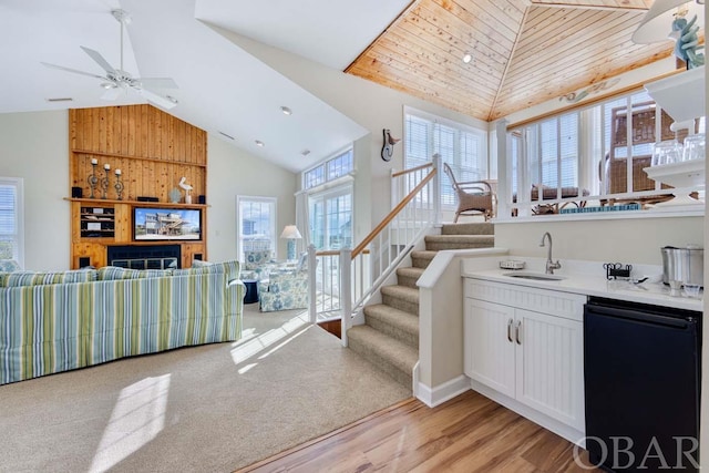 interior space featuring white cabinets, open floor plan, light countertops, high vaulted ceiling, and a sink