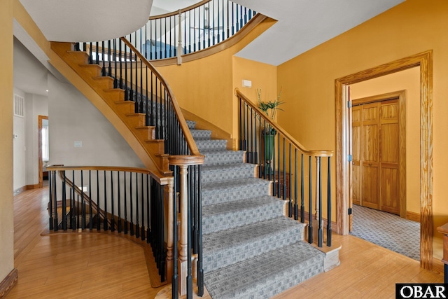 stairs featuring visible vents, baseboards, and wood finished floors