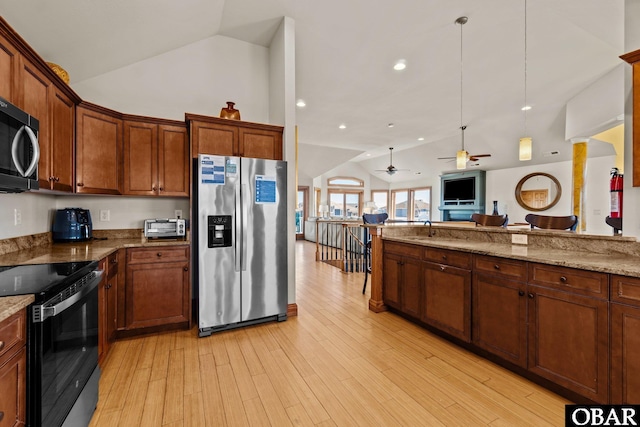 kitchen with light stone countertops, vaulted ceiling, appliances with stainless steel finishes, and open floor plan