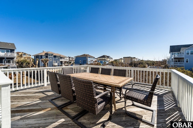 deck featuring outdoor dining space and a residential view