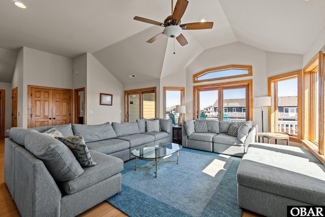 living area with ceiling fan, vaulted ceiling, and wood finished floors