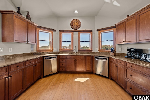 kitchen featuring dishwasher, stone countertops, a sink, and lofted ceiling