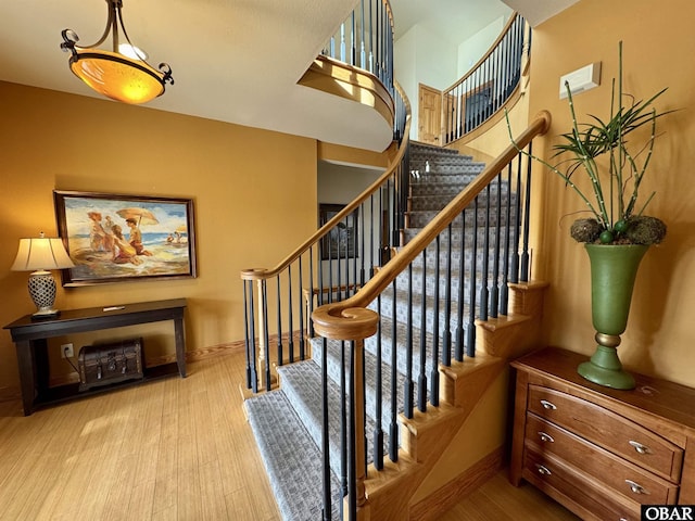 stairs with baseboards and wood finished floors