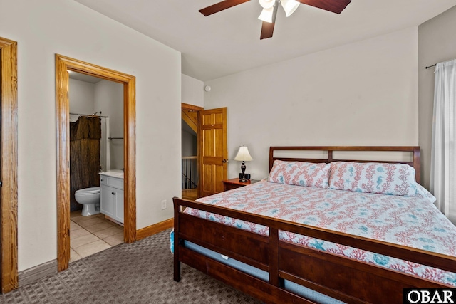 bedroom featuring light carpet, ensuite bath, a ceiling fan, and baseboards