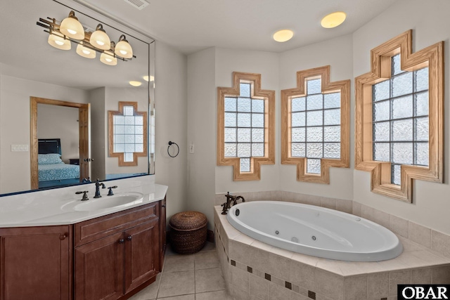 ensuite bathroom with ensuite bathroom, a whirlpool tub, tile patterned flooring, and vanity