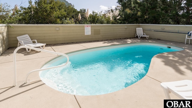 community pool featuring a patio area and fence