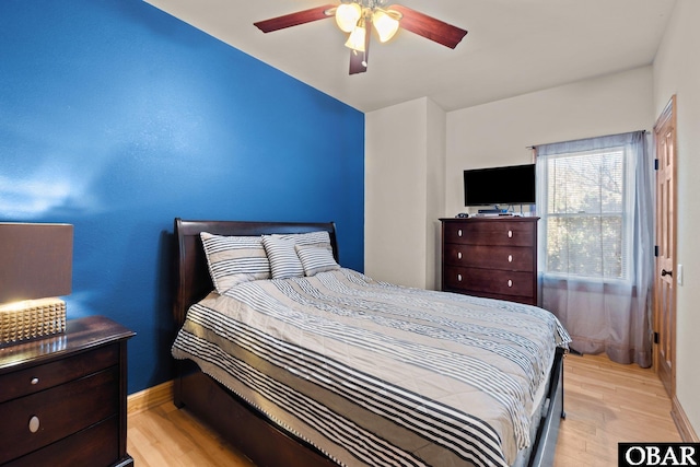 bedroom featuring light wood-style floors, baseboards, and a ceiling fan