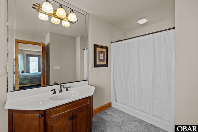 bathroom with marble finish floor, connected bathroom, vanity, and baseboards