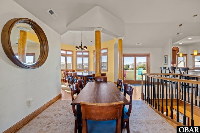 dining area featuring light wood finished floors, decorative columns, visible vents, and a chandelier