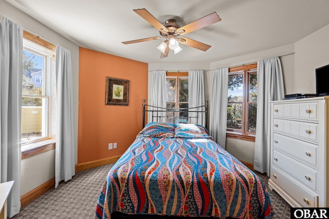 bedroom with ceiling fan, baseboards, and light colored carpet