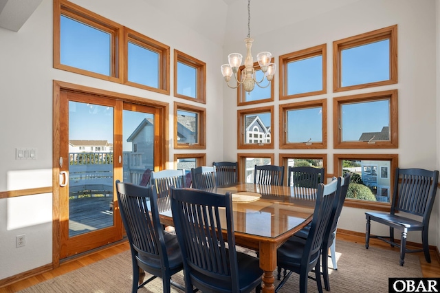 103 Halyard Ct Lot 49, Duck, NC 27949 - dining space with a chandelier, light wood finished floors, plenty of natural light, and a towering ceiling