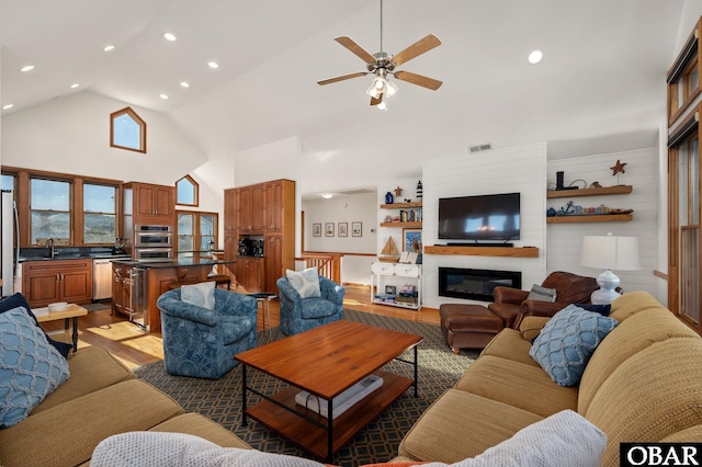 103 Halyard Ct Lot 49, Duck, NC 27949 - living room featuring light wood-type flooring, high vaulted ceiling, a ceiling fan, recessed lighting, and a glass covered fireplace